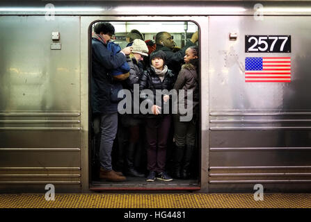 Les banlieusards cram sur une rame de métro à la Station 42e Rue à New York City. Banque D'Images