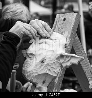 Carpenter sculpte un masque de carnaval en bois. Banque D'Images