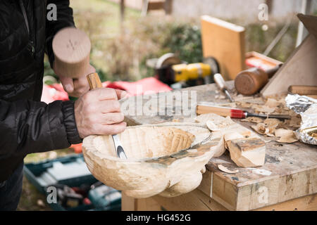 Carpenter sculpte un masque de carnaval en bois. Banque D'Images