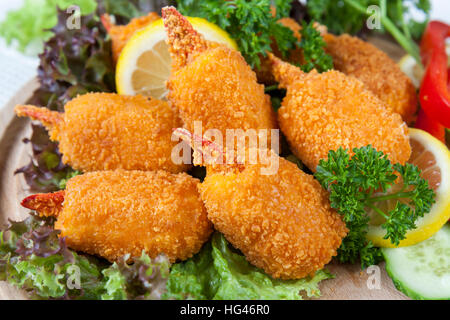 Pinces de crabe frit avec le concombre, le citron, la laitue et le persil on white plate Banque D'Images