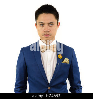 L'homme asiatique en costume bleu avec la crème à café couleur papillon Broche fleur, et motif de points, Close up. Isoler fond blanc Banque D'Images