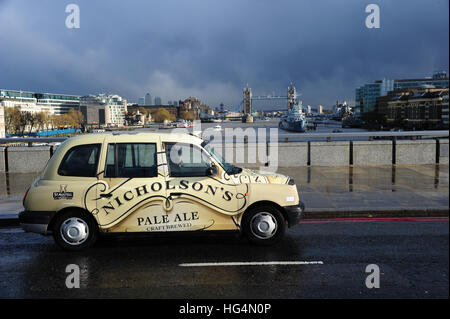 Un taxi traverse le pont de Londres avec le Tower Bridge et HMS Belfast en arrière-plan Banque D'Images