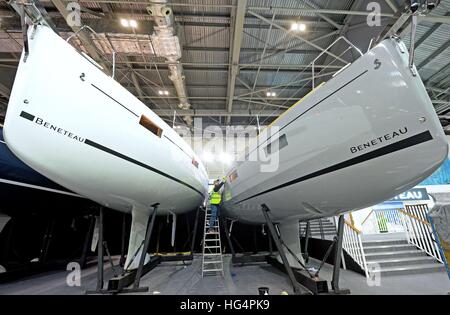 Un membre du personnel fait les derniers ajustements à un bateau Beneteau, devant le London Boat Show au centre ExCel de Londres. Banque D'Images