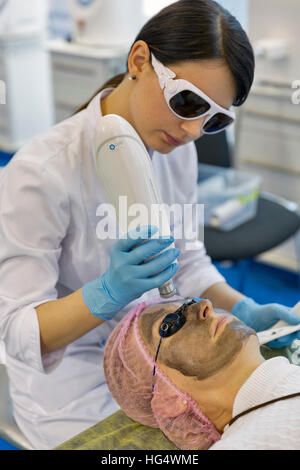 Jeune femme non reconnu thérapeute cosmétologie démontre des soins de beauté au 16ème Congrès National de la beauté. Banque D'Images