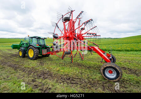 Le tracteur avec nouvelle faneuse debout dans le domaine Banque D'Images