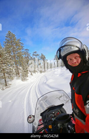 Antti, jeune guide finlandais de VisitInari, conduit une motoneige dans le désert d'Inari, Finlande Banque D'Images