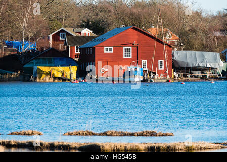 Ronneby, Suède - 2 janvier 2017 : Documentaire de vie côtière suédoise. L'ancien chantier naval à Saxemara bay vu de l'autre côté de l'eau. Banque D'Images