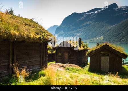 Vue sur Lac Lovatnet, une maison traditionnelle norvégienne est assis au premier plan en tête avec toit de chaume. Banque D'Images