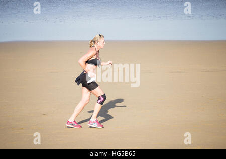 Young woman running on beach. Banque D'Images