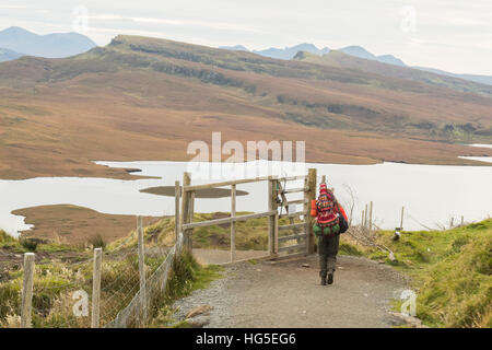 Femelle solitaire voyageur randonneur transportant sur guitare retour en ordre décroissant de l'ancien homme de Storr, île de Skye, en Écosse à l'automne Banque D'Images