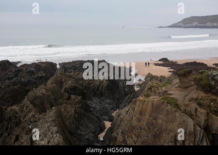 Deux surfeurs à pied à la mer en portant sa planche de surf sur une plage au Royaume-Uni. Banque D'Images