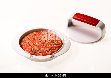 Faire des galettes de viande à hamburger parfait Patty. Restauration rapide, tartare de boeuf, hambureger, presse, accessoires presse, stamp, nouveau cycle, uniforme Banque D'Images