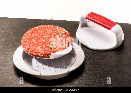 Faire des galettes de viande à hamburger parfait Patty. Restauration rapide, tartare de boeuf, hambureger, presse, accessoires presse, stamp, nouveau cycle, uniforme Banque D'Images