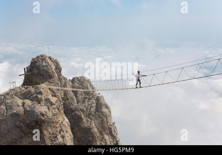 Man Crossing the Chasm sur le pont suspendu Banque D'Images