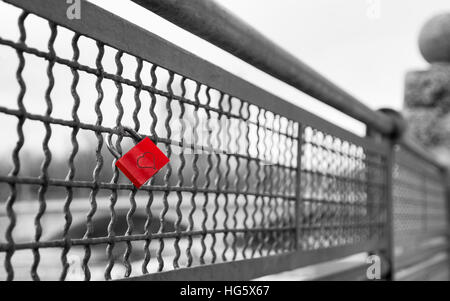 Blocage de l'amour avec forme de coeur sur le pont comme symbole de l'infini l'amour vrai. Stock photo noir et blanc avec couleur rouge sélective Banque D'Images