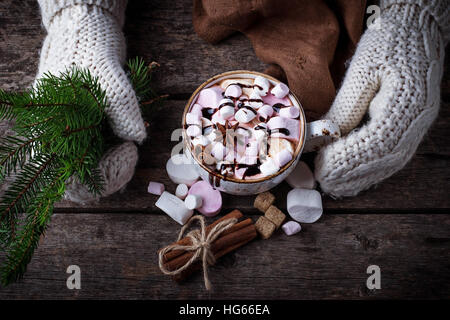 Mitaines femme en tenant une tasse de chocolat chaud avec de la guimauve. Selective focus Banque D'Images