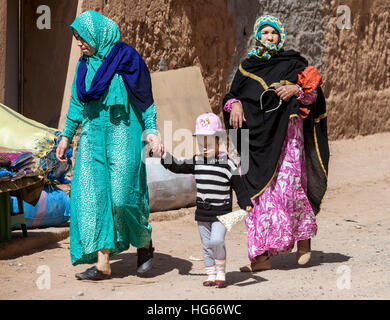 Elkhorbat, Maroc. Les femmes berbères et de la jeune fille marche dans le marché. Banque D'Images