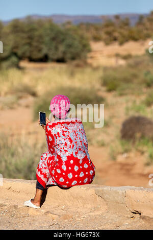 Elkhorbat, Maroc. Jeune femme berbère en utilisant son téléphone cellulaire. Banque D'Images