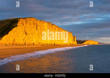 West Bay, Dorset, UK. 4 janvier, 2017. Météo britannique. L'emblématique falaise Est de West Bay, sur la côte jurassique du Dorset, luit dans la lumière dorée de fin d'après-midi sur un après-midi calme comme le nuage construit peu avant le coucher du soleil. East Cliff et West Bay dispose de dans la série à succès d'ITV Broadchurch avec David Tennant et Olivia Colman. Photo © Graham Hunt/Alamy Live News Banque D'Images