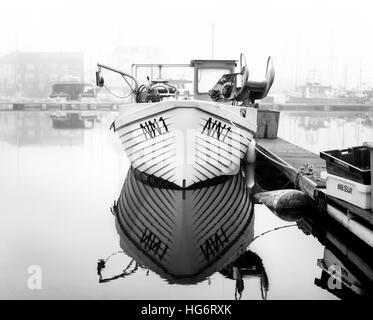 Photo en noir et blanc d'un bateau amarré dans un port local Banque D'Images