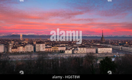 Torino (Turin, Italie) : vaste paysage urbain au crépuscule avec lumière colorée sur les pittoresques Alpes enneigées en arrière-plan. Banque D'Images