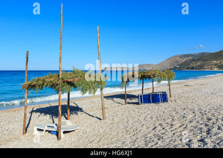 Matin d'été plage avec chaises longues et des auvents (Borsch, Albanie). Banque D'Images