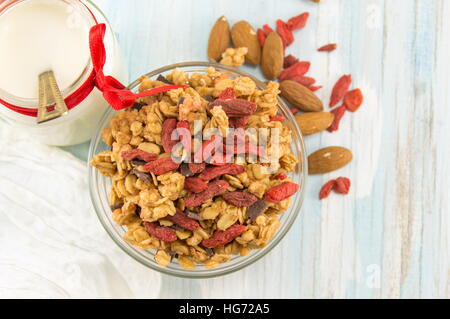 Céréales muesli muesli aux fruits secs dans un bol avec du lait Banque D'Images