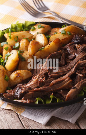 Des pommes de terre et de porc sur une assiette. sur la table verticale. Banque D'Images