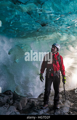 Grimpeur sur glace dans la caverne de glace à Breidamerkurjokull Breiðamerkurjökull Grotte de glace, Crystal Cave dans le parc national du Vatnajökull, au Sud Est de l'Islande en Janvier Banque D'Images