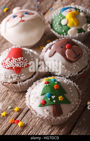 Belle ambiance festive cupcakes avec décorations de Noël close-up sur une table en bois. La verticale Banque D'Images