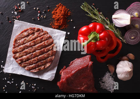 Burger de viande de boeuf haché cru escalopes steak avec des ingrédients sur la carte Vue de dessus horizontale. Banque D'Images