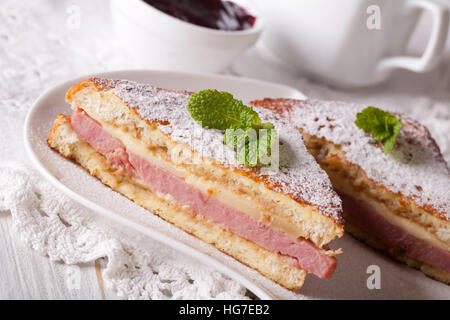 Sandwich de Monte Cristo avec jambon et fromage sur une plaque horizontale. Banque D'Images