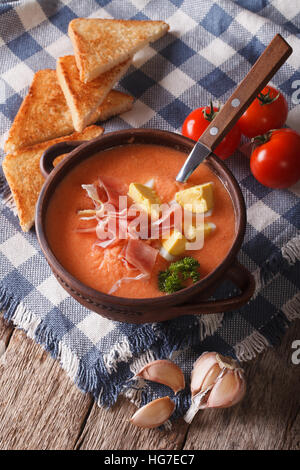 Soupe Salmorejo avec du jambon et d'œufs dans un bol sur la table. La verticale Banque D'Images