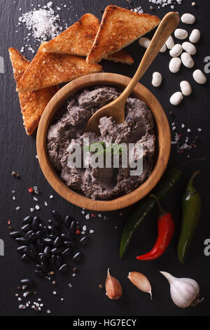 La cuisine mexicaine : pate de haricots noirs gros plan sur la table. vertical vue d'en haut Banque D'Images