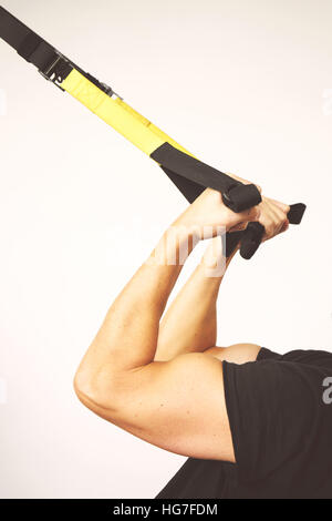 TRX. Les mains des hommes avec des sangles TRX fitness dans une salle de sport. Banque D'Images