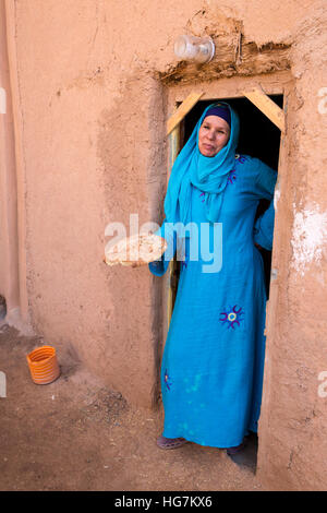 Ksar Elkhorbat, Maroc. Femme berbère Amazigh dans sa porte maintenant du pain. Banque D'Images