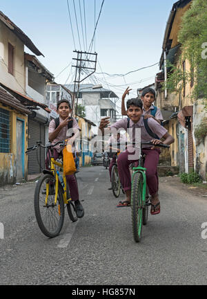 Des écoliers sur les bicyclettes dans les rues de ville juif, fort Kochi, Cochin, Kerala, Inde Banque D'Images