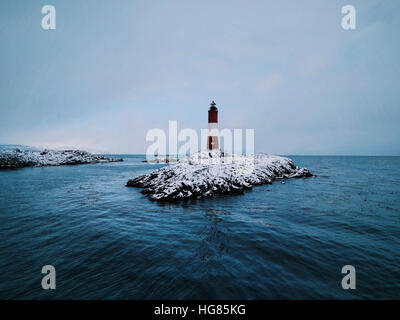 Phare sur la mer au milieu de la formation de la roche contre le ciel au cours de l'hiver Banque D'Images