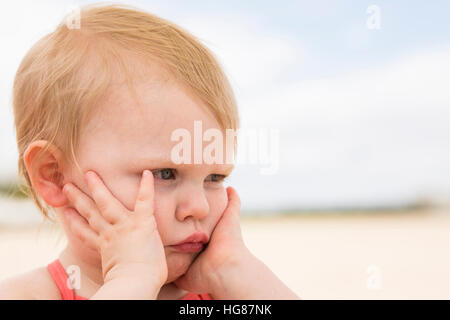 Bored girl with blindfold against sky Banque D'Images