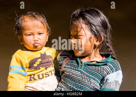 Portrait, young girl lying encore plus jeune garçon, Ghandruk, district de Kaski, Népal Banque D'Images