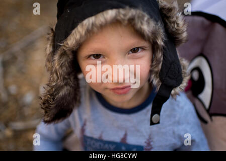 Portrait of boy wearing cap chasseurs tandis qu'assis sur une chaise Banque D'Images