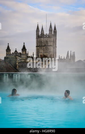 La vapeur s'élève au-dessus des eaux de source naturelle chaude sur le toit au spa Thermae Bath Spa, comme les gens profiter de la vue sur l'abbaye de Bath et le contraste entre l'eau chaude et de gel à l'extérieur des températures élevées pendant la période de froid dans certaines parties du Royaume-Uni. Banque D'Images