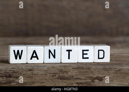 Voulu, écrit en cubes sur fond de bois Banque D'Images