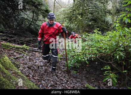 Les membres de l'Écosse de la police l'unité de police maritime vérifiez les étangs et cours d'eau dans les bois et champs proches de la scène d'une maison en feu à Milngavie, Merville, qui a coûté la vie de Cameron Logan. Banque D'Images