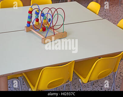 Chaises jaune avec petits bancs à l'intérieur d'une garderie Banque D'Images