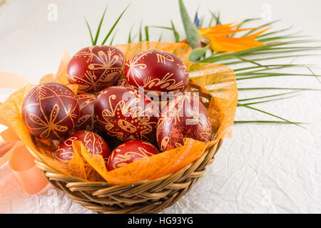 Oeufs de Pâques décorés avec de la cire et fleur orange Banque D'Images