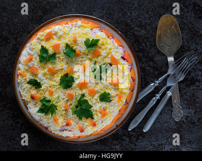 Le hareng sous un manteau de fourrure, une salade faite de filet de hareng salé, des pommes de terre, betteraves, carottes, oignons frais et la mayonnaise sur une plaque Banque D'Images