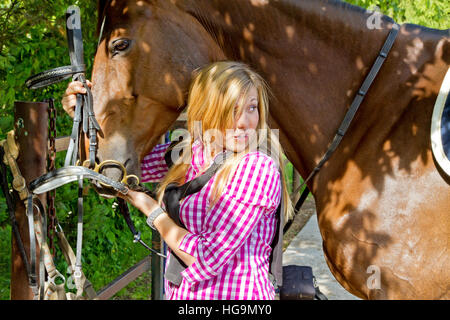 Jeune femme son cheval de selle Banque D'Images