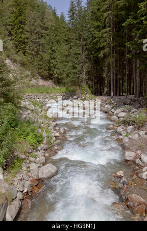 La voler-pêche dans un ruisseau proche de Rapide chutes Stuibenfall, vallée de l'Ötztal, Umhausen, Autriche. Banque D'Images