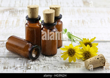 Arnica homéopathique comprimés dans des flacons en verre brun sur table en bois Banque D'Images